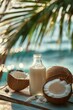 Coconut milk in a bottle with coconuts on the beach. Vertical photo with coconut milk.