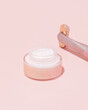 Pink jar of skincare cream on pink background