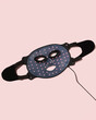 Red light therapy mask on pink background