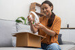 shopping addicted woman unboxing new parcel with gadget headphones delight through e-commerce and rapid express online shopping.