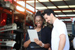 © Stella - Happy harmony people at workplace, smiling white guy and African American woman working together Two workers check stock at auto spare parts store shop warehouse, surrounded by secondhand engine parts