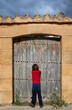 Niño cuenta de espaldas, frente a una vieja puerta de madera, para iniciar el juego del escondite en el pueblo de Fuentespalda, Teruel (Aragón), España.