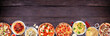 Delicious Italian food bottom border. Selection of pizzas and pastas. Top view on a dark wood banner background. Copy space.