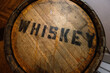 wood Whiskey barrel with black stamped letters spelling whiskey