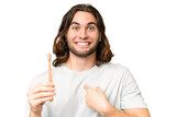 Fototapeta Na drzwi - Young handsome man brushing teeth over isolated background with surprise facial expression