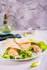 Wall Mural - Dietary grilled tacos with chicken fillet, lettuce on a plate on the table vertical view