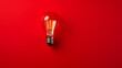 red light bulb on red background 