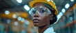 © FryArt - A Black African woman engineer worker is seen wearing safety goggles and a hard hat at a construction site.