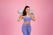 Fit woman with yoga mat on pink background