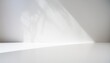 © imstock - Base o mesa de color  blanco y una pared lisa blanca y sombras, detalle de una habitación vacía