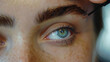 Close-up of a woman applying mascara on eyelashes.