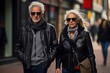 A man and a woman are walking down a street wearing leather jackets