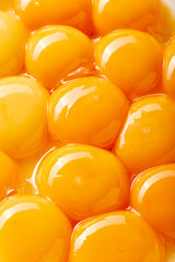 Sticker - Close-up of several large yolks. The eggs are arranged in a way that creates a sense of depth and texture, with some eggs overlapping each other.