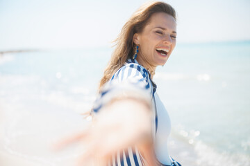 Wall Mural - happy stylish woman on ocean coast having fun time