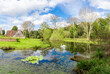 Spring serenity: Captivating nature scene with green plants and trees surrounding a pond in Scadbury natural park near Bromley area in London