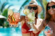 Women clinking glasses with cocktails at poolside