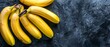   A pair of ripe banana bunches resting on a black countertop adjacent to one another