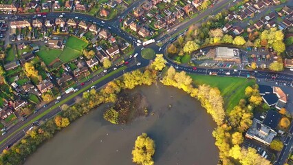 Wall Mural - Aerial footage of the village known as Farnley in Leeds, West Yorkshire UK showing the housing estates and busy morning traffic and roundabout on the main road taken in the autumn time.