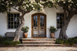 Charming entrance of a house with blooming trees and potted plants.