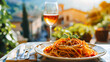 Assiette de spaghettis ç la tomate et au basilic avec verre de vin et village typique en fond