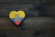 wooden heart with national flag of ecuador on the wooden background.