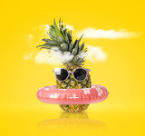 Fototapeta Kuchnia - Pineapple with ring float and sunglasses on a yellow background. Creative concept summer beach holiday