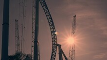 Amusement Park Visitors Ride On Reverse Bungee. Sunset.