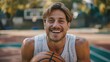 Happy beautiful man holds a basketball in his hands and laughs while looking at the camera