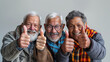 © Leopoldine - Groupe de trois amis âgés, 60 à 70 ans, levant le pouce vers le ciel, fond blanc, sortie entre seniors