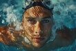 A male swimmer's face emerges from a sparkling sunlit pool with goggles
