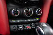 © Harry - The dashboard of a car has a red trim and three buttons on it. The buttons are labeled with the letters A, B, and C