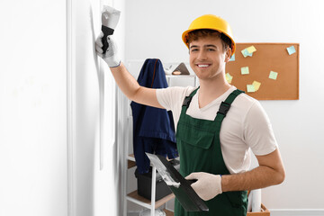 Canvas Print - Male decorator with putty knives working in room