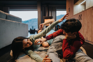 Wall Mural - Group of friends lying down on the floor, enjoying a break and casual interaction in a cozy home setting.