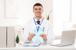 © Pixel-Shot - Male urologist with blue ribbon in clinic. Prostate cancer awareness concept