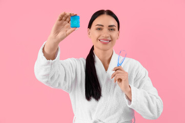 Sticker - Beautiful young happy woman in bathrobe with dental floss and tongue scraper on pink background