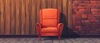 An orange chair sits on the hardwood floor in front of a wooden wall and brick wall in the building. The automotive lighting enhances the comfort of the room with tints and shades
