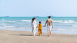 © CandyRetriever  - Happy Asian family travel ocean on summer holiday vacation. Parents and little daughter girl enjoy and fun outdoor activity lifestyle walking and playing together on tropical island beach in sunny day