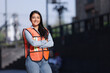 mexican working woman engineer smiling with crossed arms looking at the camera with a city background