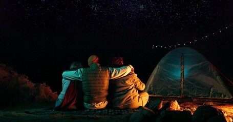 Poster - Friends, hug and camping with stars at night for adventure, holiday fun and outdoor activity. Campsite, people and pointing to sky with embrace, tent in nature and travel with hand gesture in woods