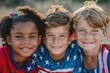 Three kids wearing patriotic clothing smile brightly, showing diversity and joy.