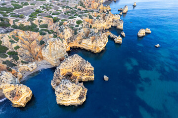 Wall Mural - Sunrise over Ponta de Piedade, Algarve cliffs on coastline. Aerial drone view