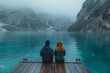Couple by a mountain lake on a foggy day, pristine waters reflecting nature.