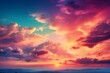 A beautiful sunset with a sky full of colorful clouds, with hues of pink, purple, orange, and blue. The sun is setting behind a mountain range.