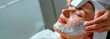 Within the soothing atmosphere of a spa, a woman's face is caressed with a frothy mask, symbolizing the art of sophisticated skincare rituals. Banner. Copy space