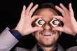 © PRO Balance - A businessman expresses emotions with his hands and face with wooden blocks and signs of EURO. Business concept for profit, income, win. Information. Symbol.