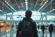 © Di Studio - travel concept, rear view of man with backpack in the airport