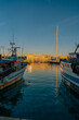 Vista panoramica sul porto di Trani al tramonto con barche e pescherecci di pescatori. Puglia, Italia.