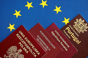 Wall Mural - European union countries passports on blue EU flag close up. Portugal, German, French and Polish passports