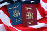 Fototapeta  - Passport of Spain with US Passport on United States of America folded flag close up