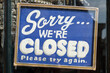 Sorry we're closed vintage blue and white retro text sign behind the glass of the store window
